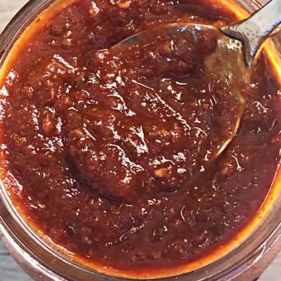 jar and spoon of taco sauce with fire roasted tomatoes