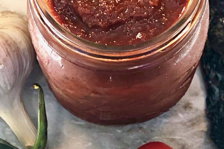 sauce in jar with vegetables on counter